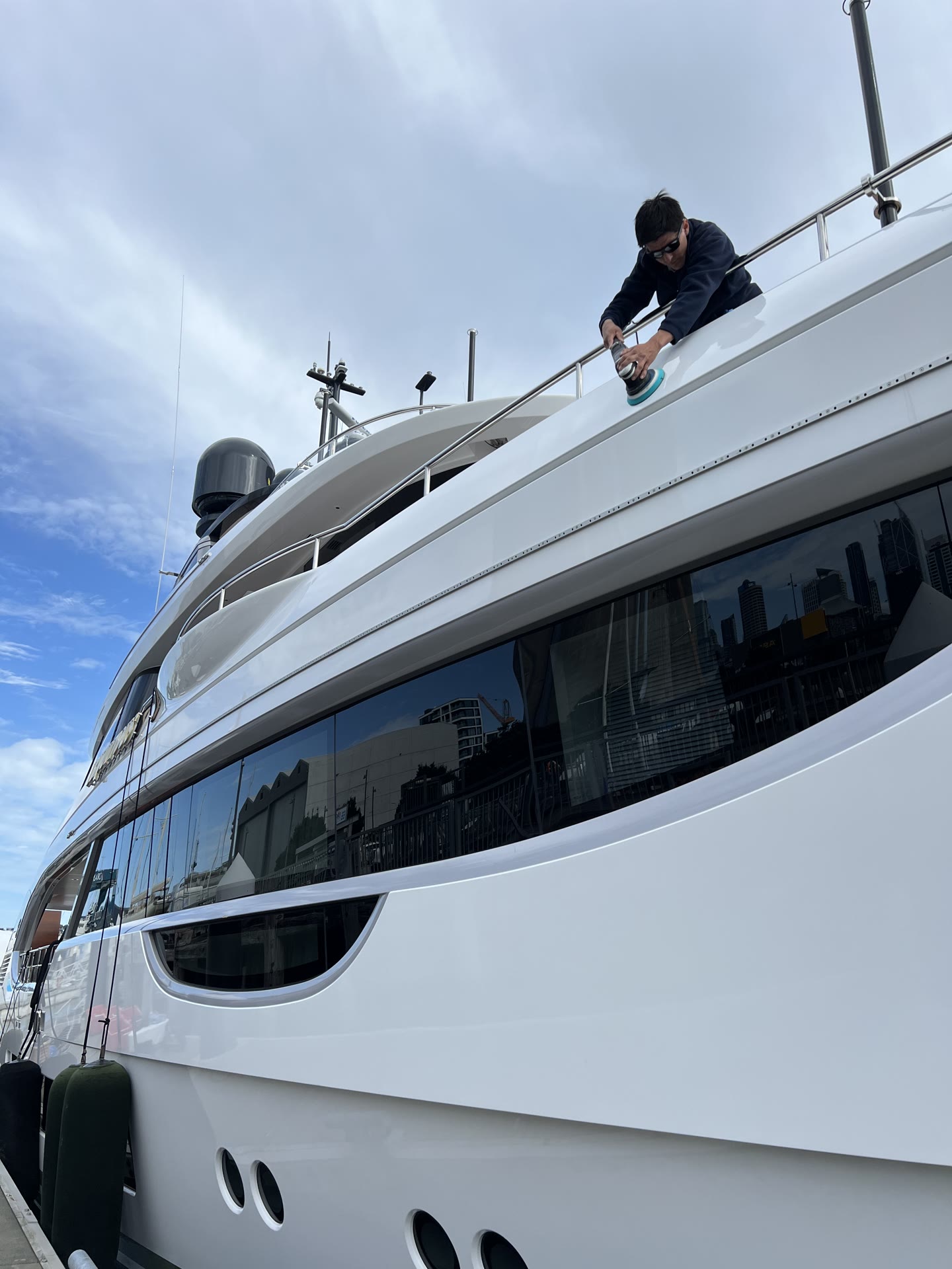 Technician machine polishing the upper deck of a superyacht