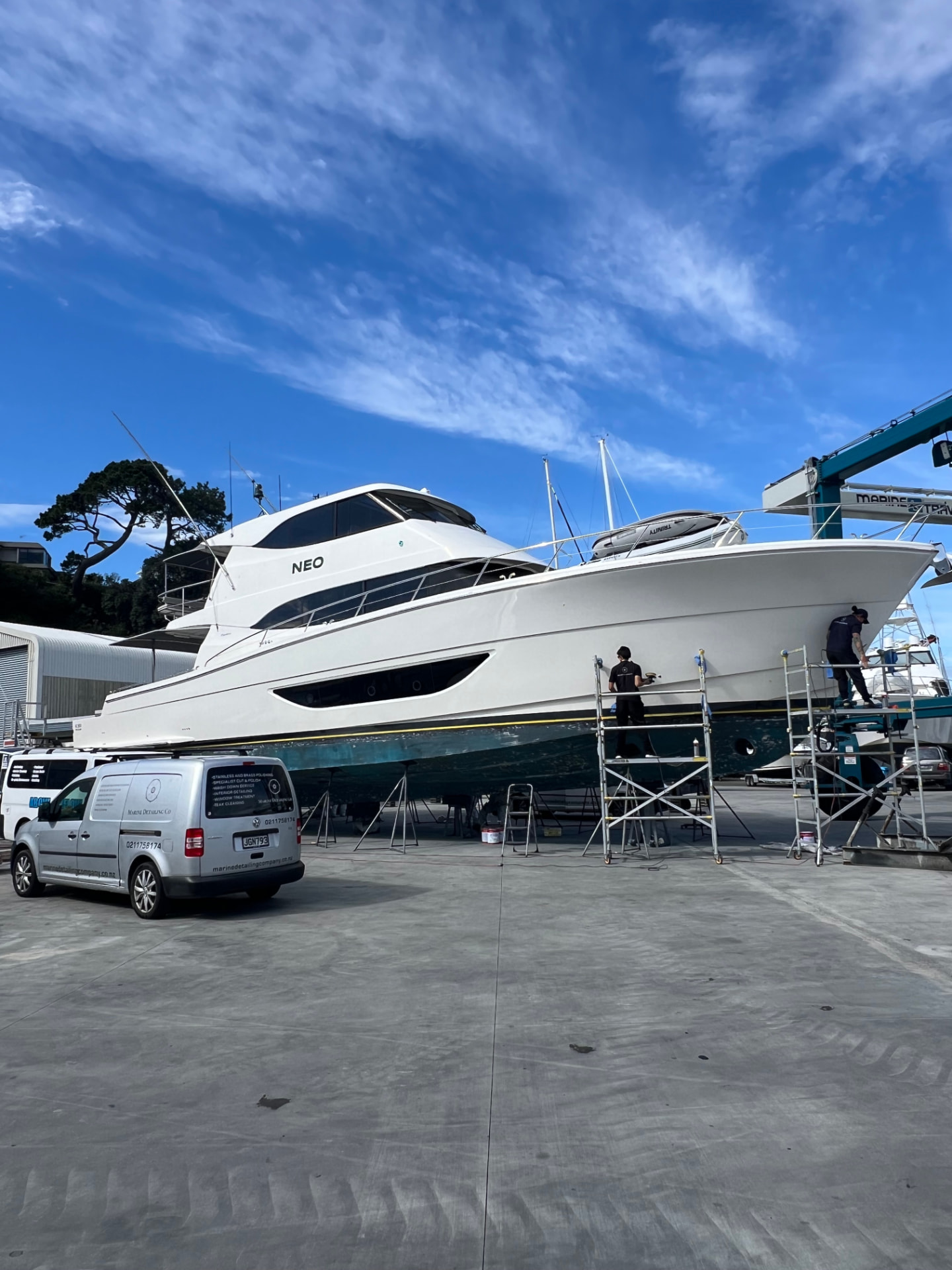 Marine Detailing Co. team polishing a motor yacht hull on the hardstand